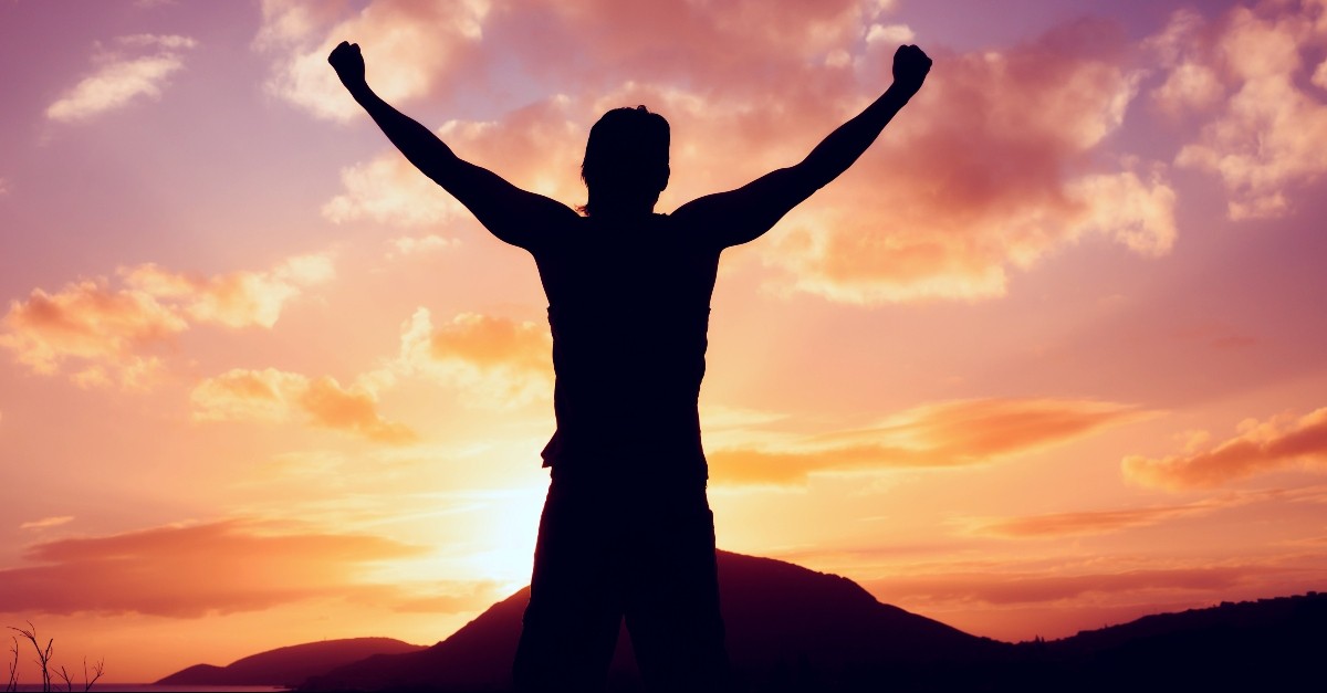 Man with arms up in victory; Easter promises victory over death.