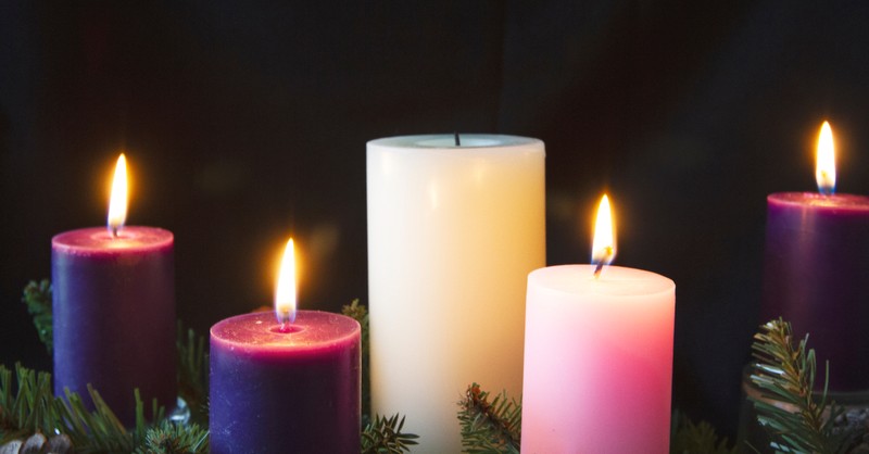 four advent candles lit including the pink candle for joy on the third sunday of advent
